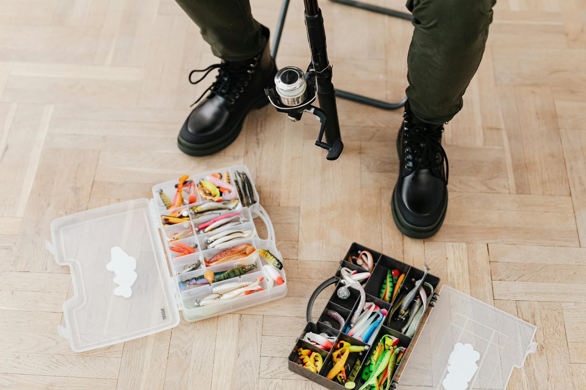Skrzynki z przynętami wędkarskimi i buty na drewnianej podłodze
